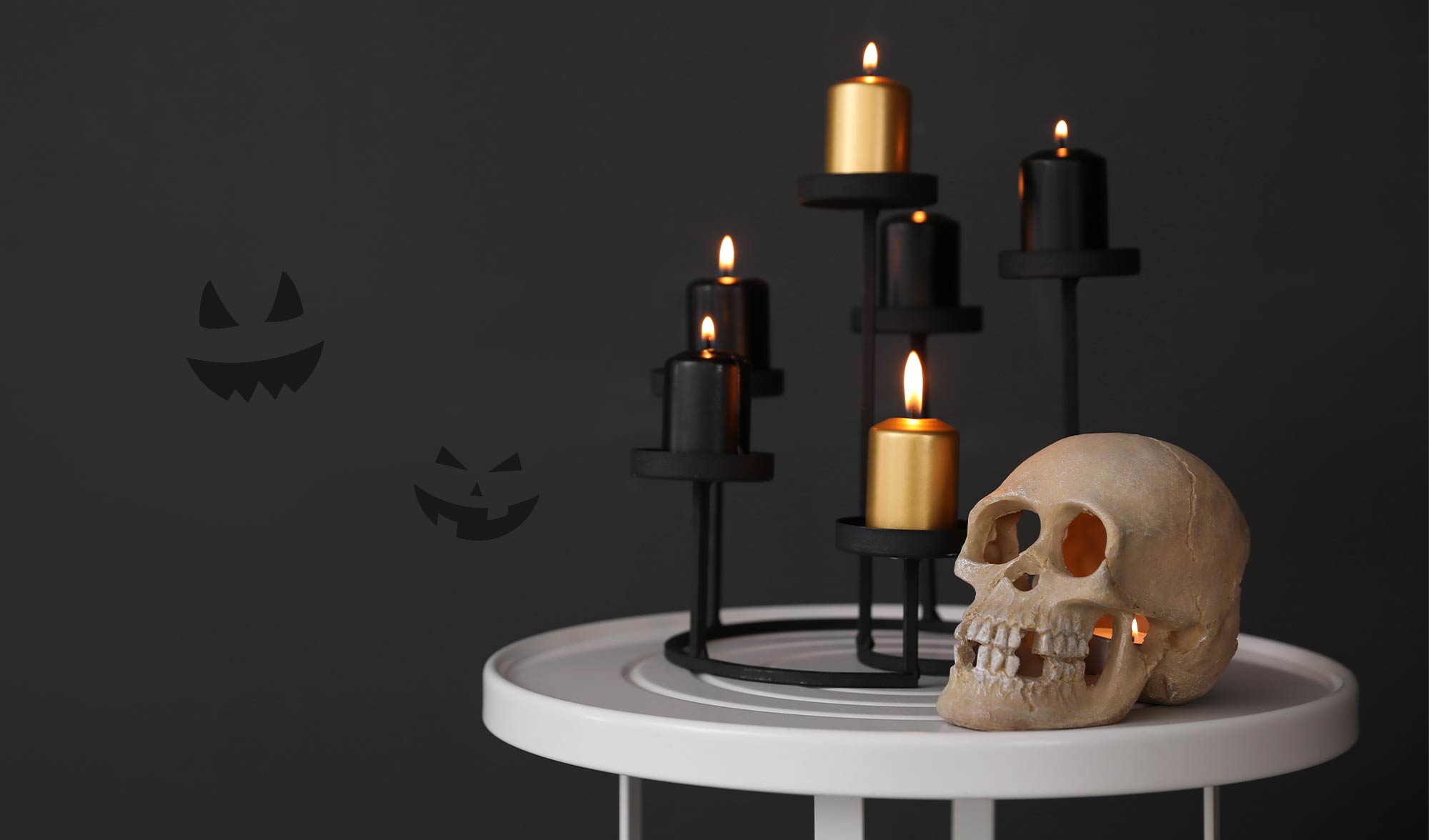 Spooky themed setting with halloween decor on table 