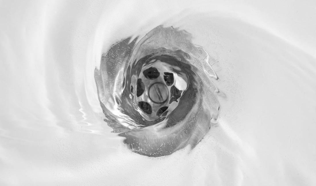overhead shot of water going down the drain 