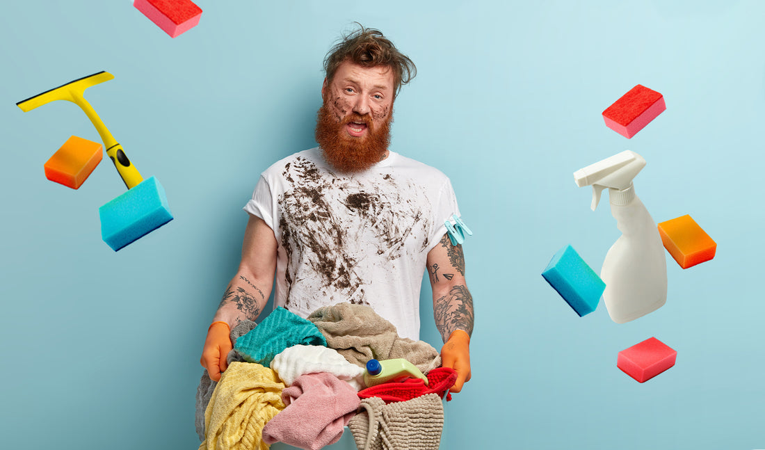 Bearded man covered in dirt, holding laundry basket 
