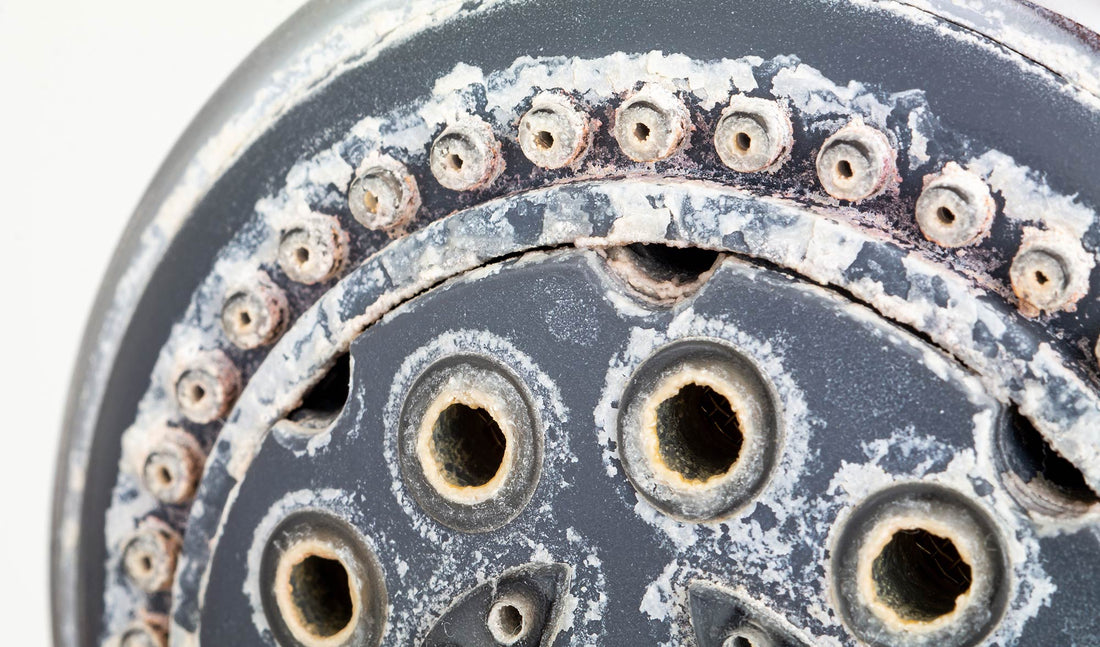Close up shot of shower faucet with rust buildup 