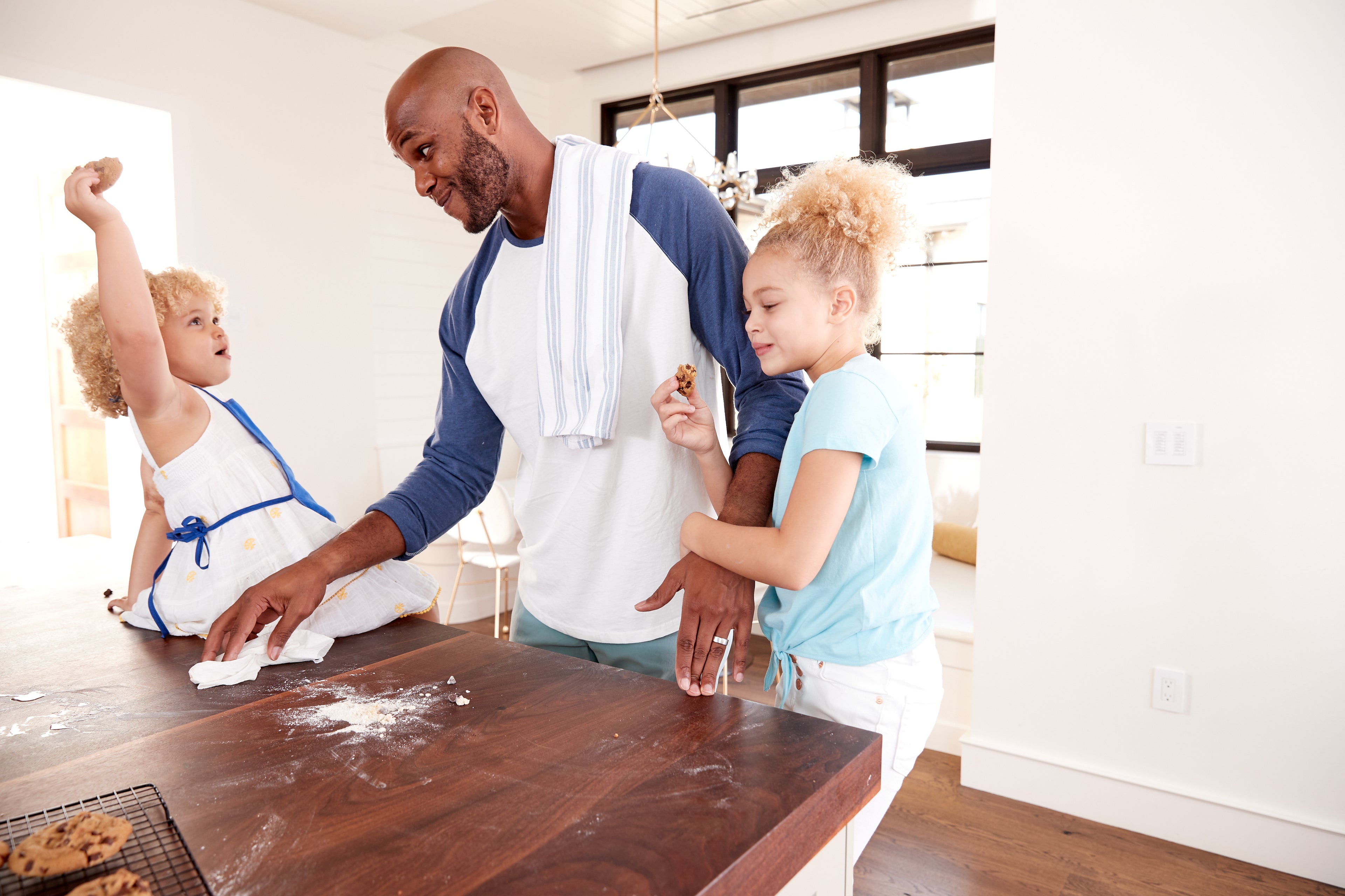 father and daughters cleaning up mess in kitchen 