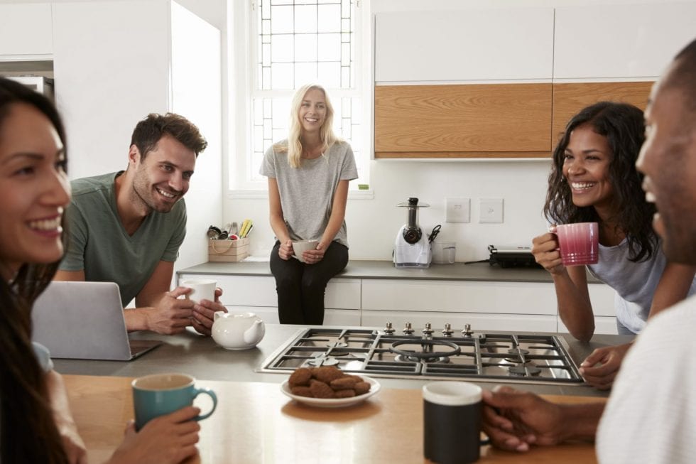 group of friends smiling in kitchen 