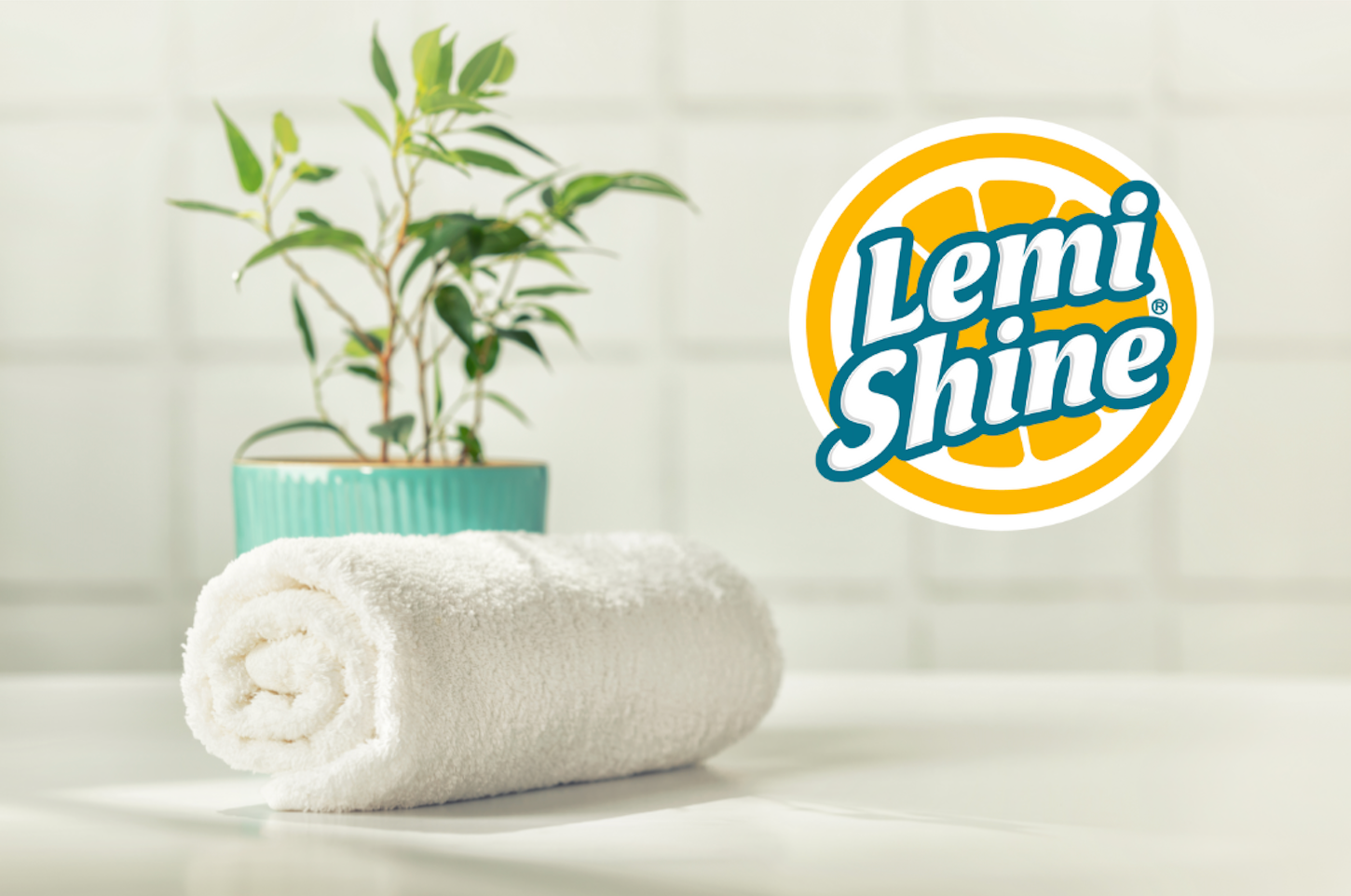 Lemi Shine logo with bathroom tiles in background. white towel and plant on countertop