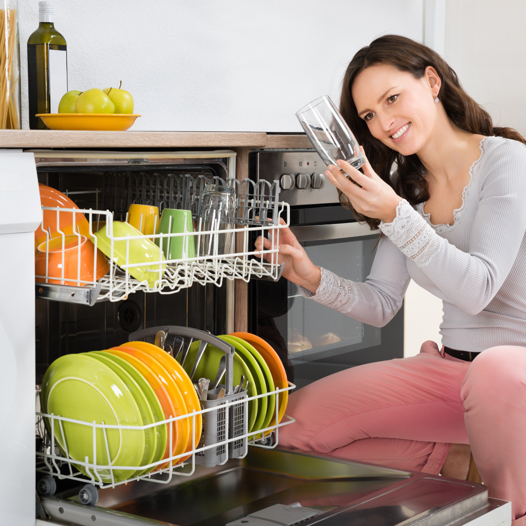 woman admiring a sparkling clean glass after a dishwashing clean