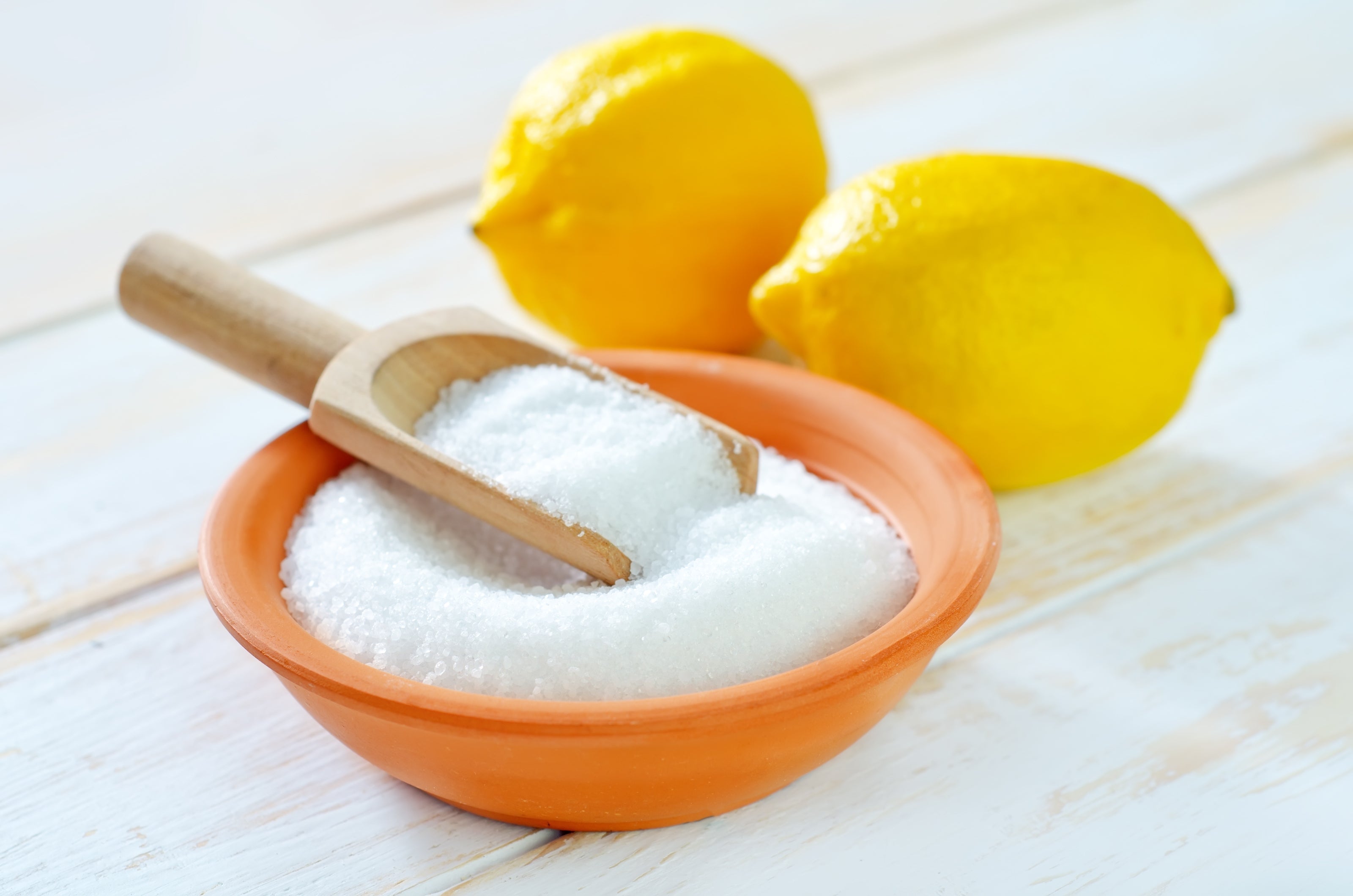 lemons and citric acid in a bowl and spoon